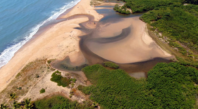 O rio Guaiú desaguando no mar ne praia de Guaiú em Cabrália - BA